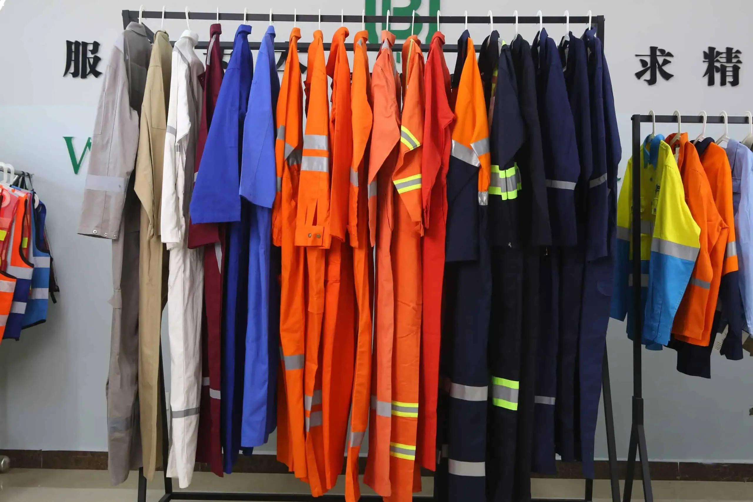 Racks of finished workwear in orange, navy, grey, and hi-vis colourways at a China workwear manufacturer