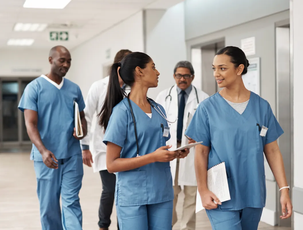 Clinical staff in blue scrubs in a hospital corridor