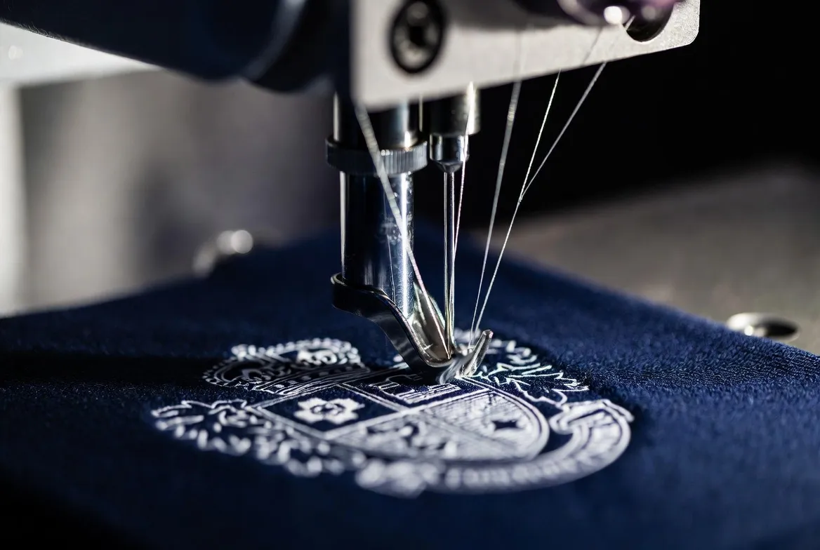 Close-up of embroidered school crest — stitch density and stabiliser quality