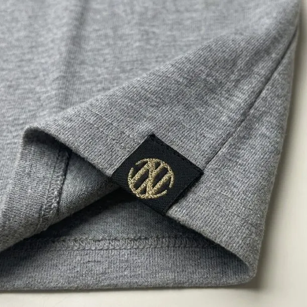 Woven label manhattan fold with metallic thread detail on private label garment