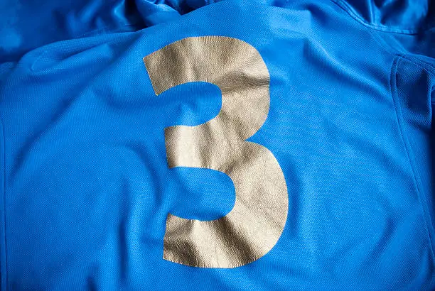 Metallic foil screen print with reflective finish on dark garment