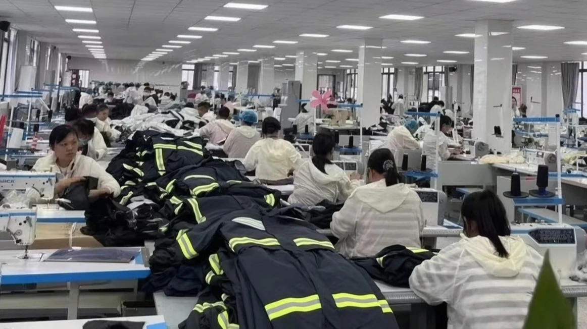 Production line with operators assembling hi-vis safety vests