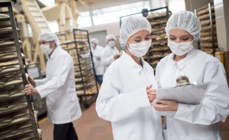 Food service kitchen staff in food-safety-compliant uniforms with HACCP-aligned design