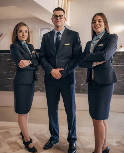 Hotel front-desk staff in a navy hospitality uniform program